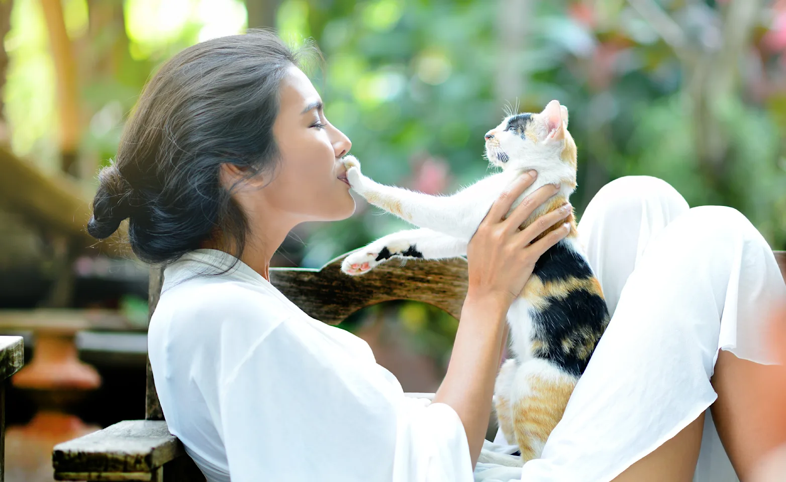 Woman with cat outside sitting down