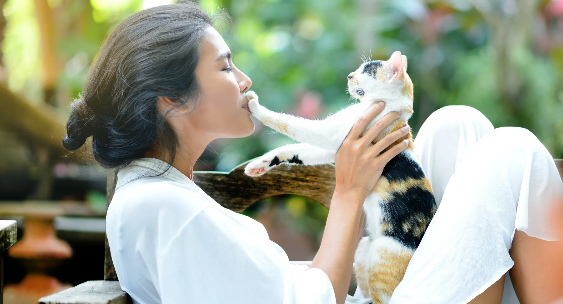 Woman with cat outside sitting down