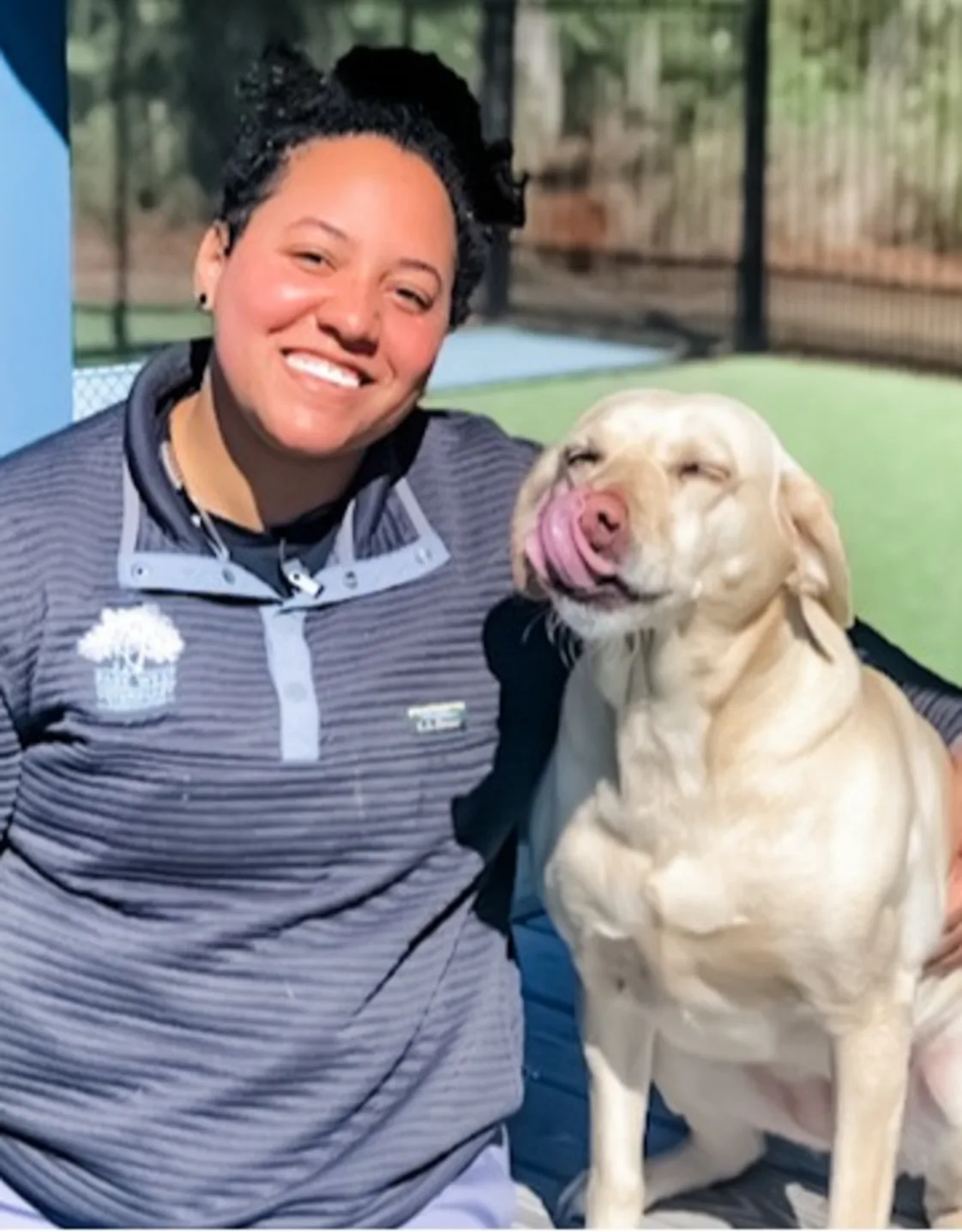 Taylor Anthony smiling kneeling down hugging a white large puppy Taylor Anthony smiling kneeling down hugging a white large puppy