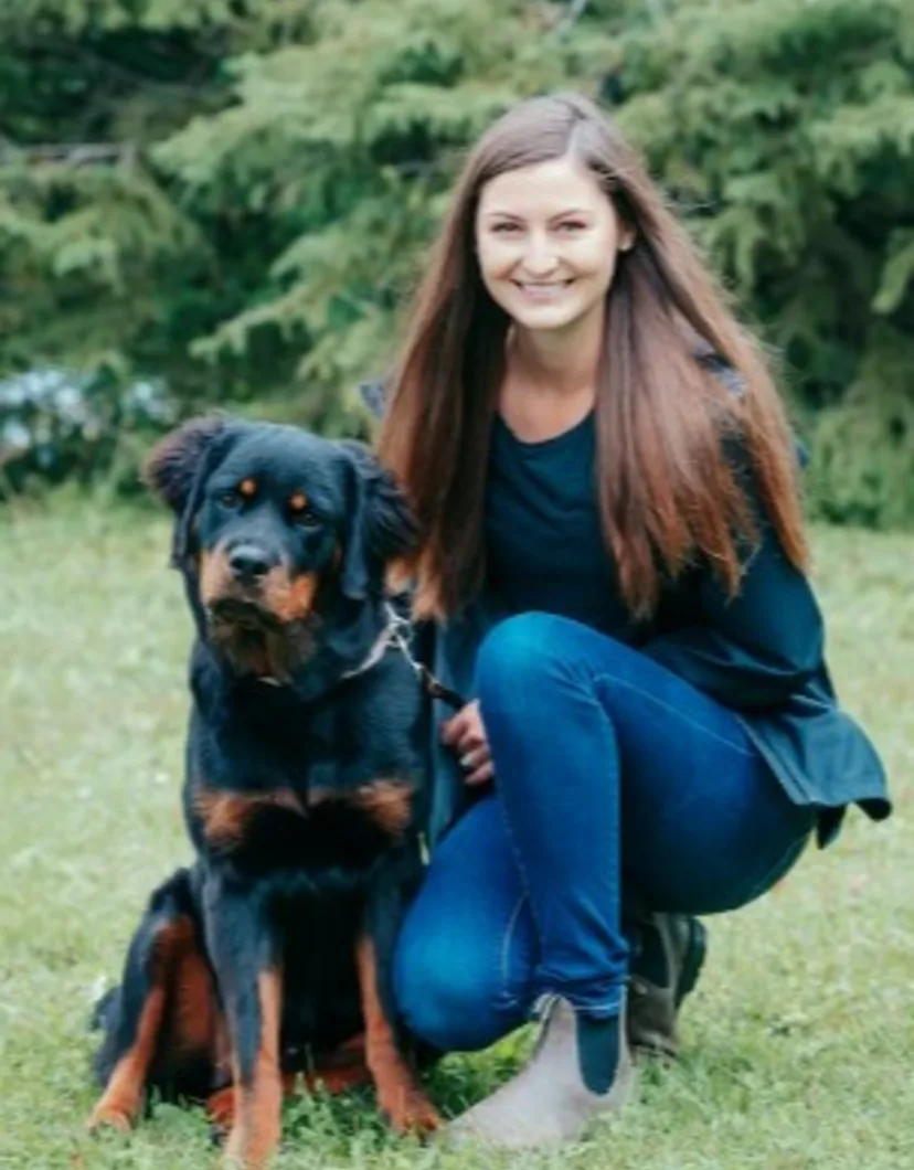 Taylor kneeling next to a large dog