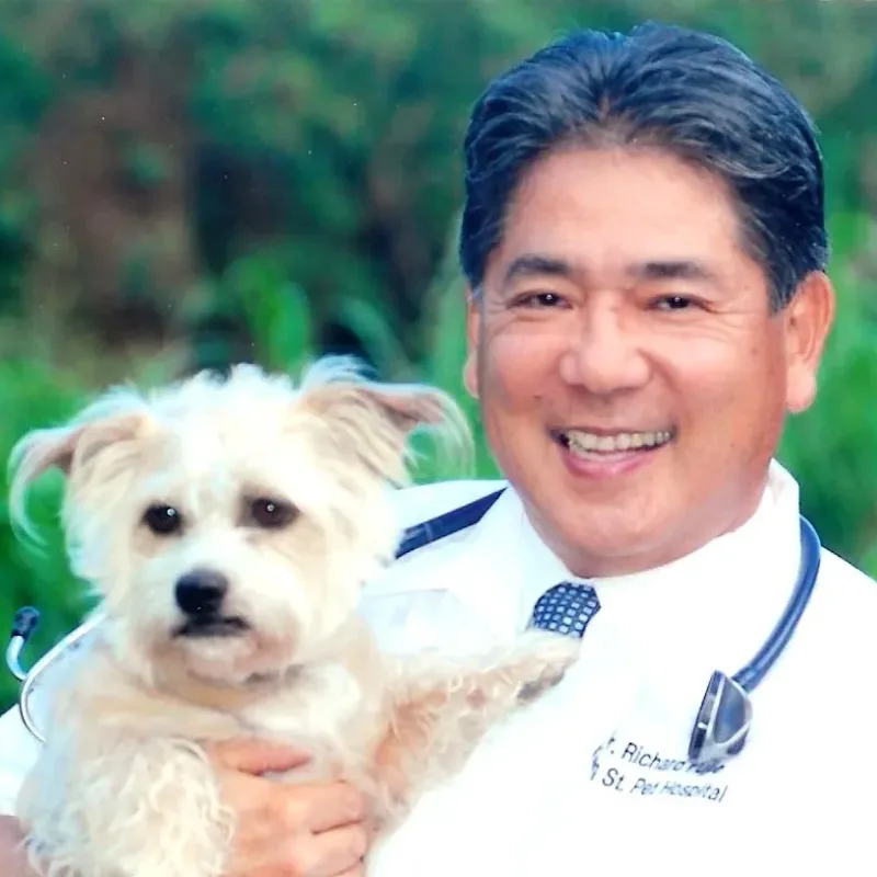 Dr. Richard Fujie holding up a white dog Dr. Richard Fujie holding up a white dog