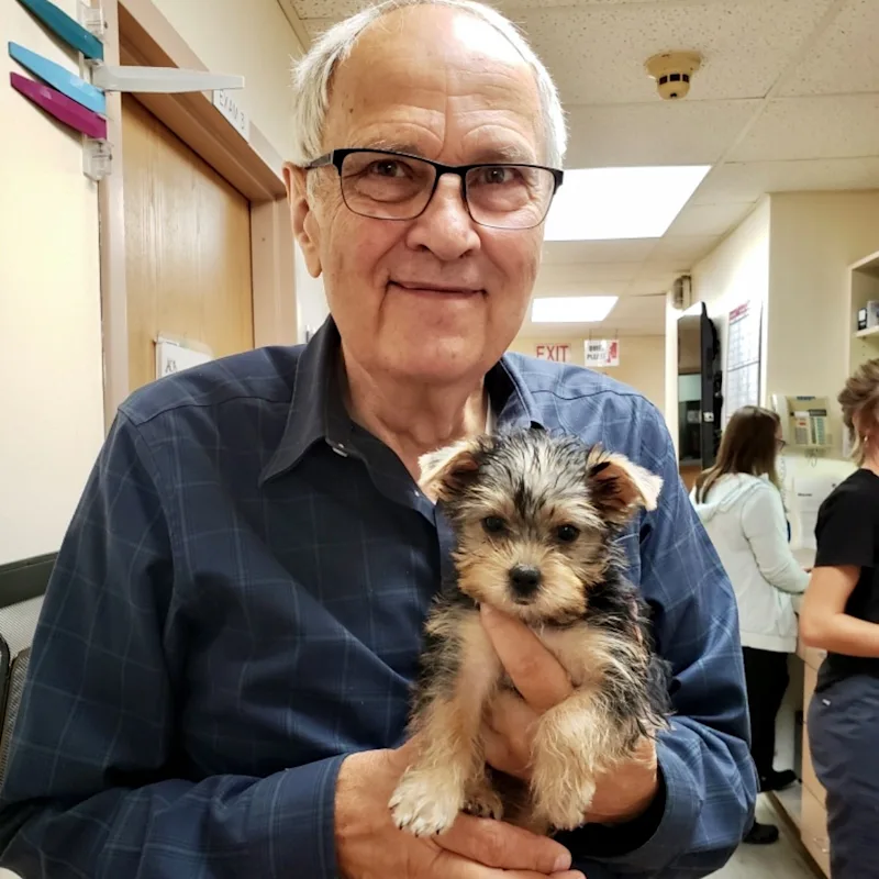 Dr. Anthony C. Burgett holding small puppy Dr. Anthony C. Burgett holding small puppy