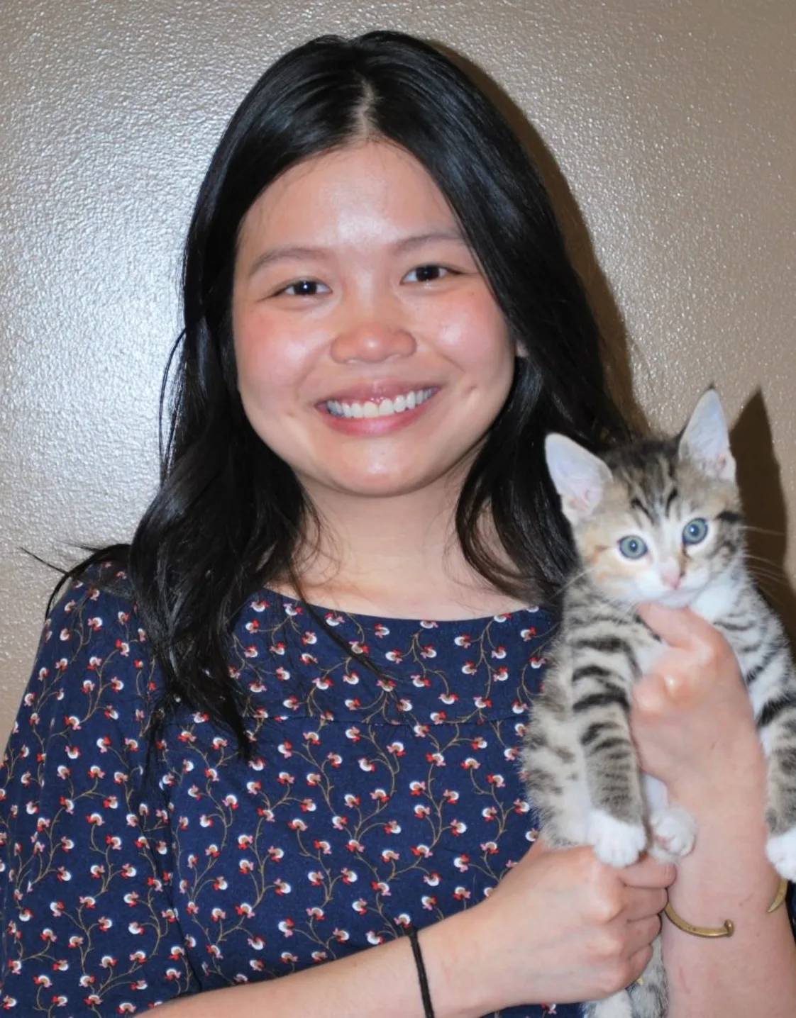 Dr. Maryse Arteficio smiling at the camera while holding a cat Dr. Maryse Arteficio smiling at the camera while holding a cat