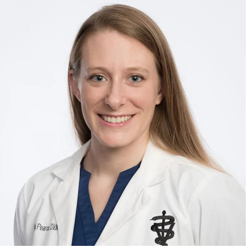 Dr. Pearce smiling in a white coat. Dr. Pearce smiling in a white coat.