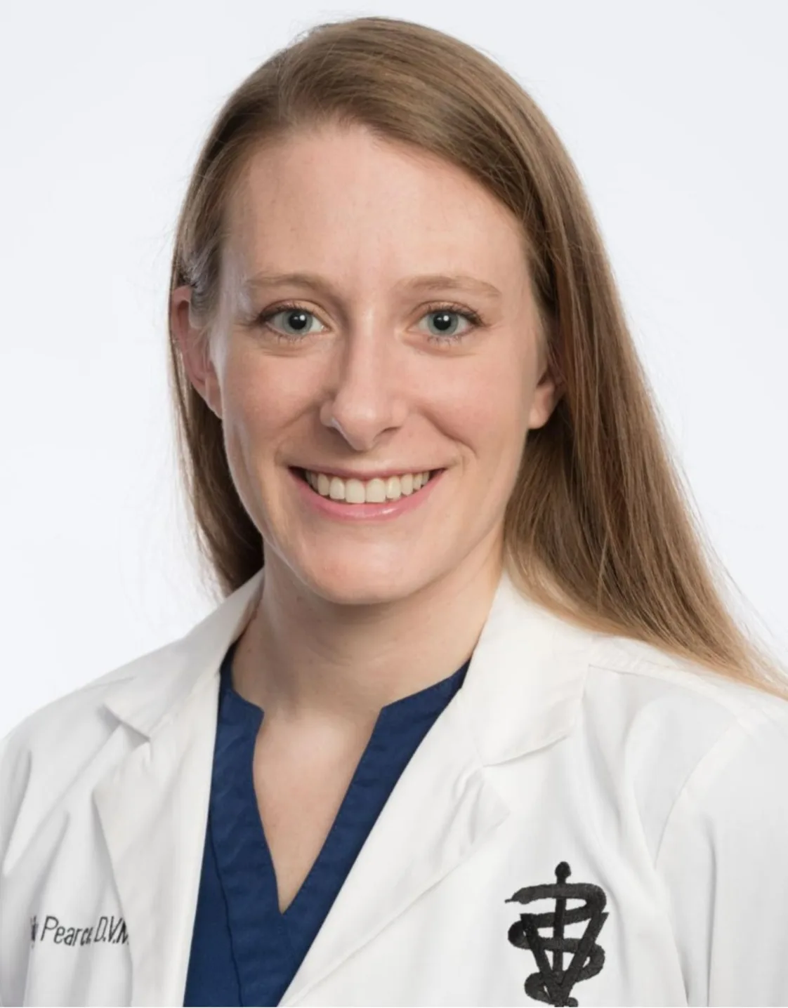 Dr. Pearce smiling in a white coat. Dr. Pearce smiling in a white coat.