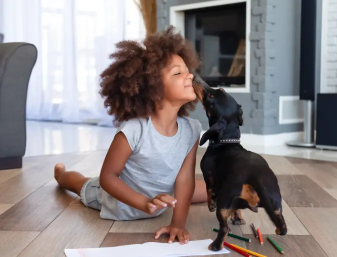 Kid with dog licking his nose