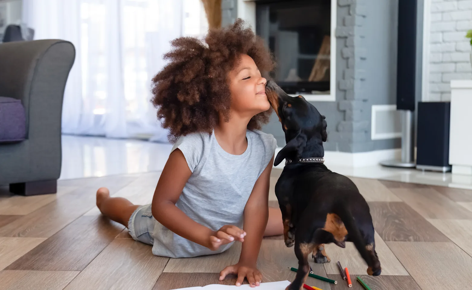 Kid with dog licking his nose