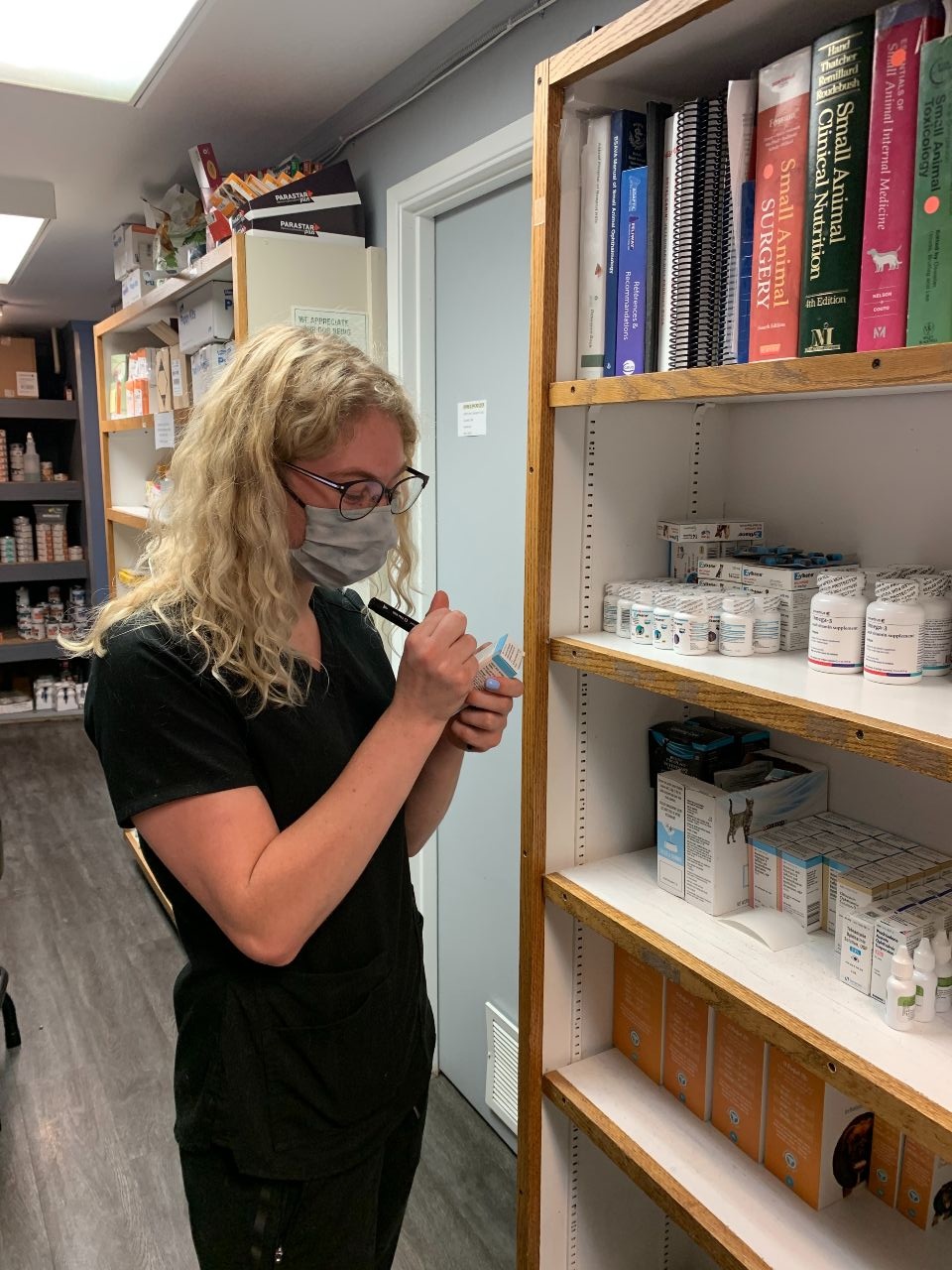 Staff writing into medications at clinic pharmacy
