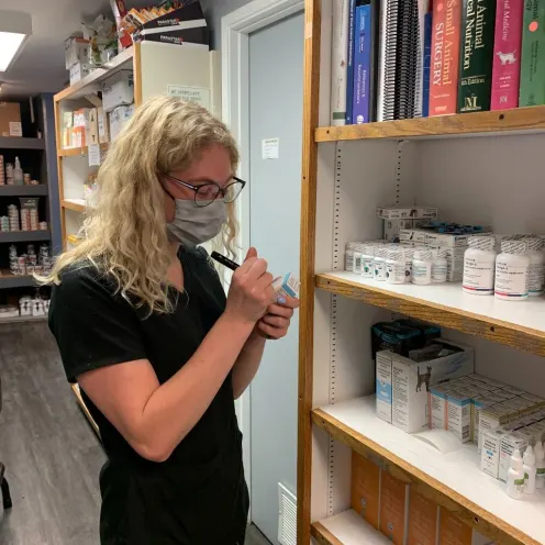 Staff writing into medications at clinic pharmacy