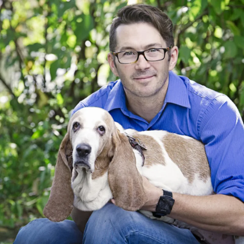 Dr. Stephen Ganton holding a tan and white dog in his lap Dr. Stephen Ganton holding a tan and white dog in his lap