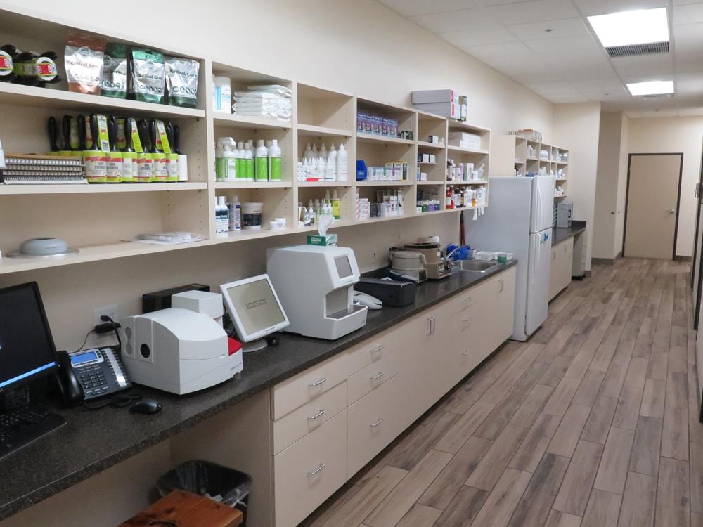 A pharmacy displaying its shelves containing all sorts of medication, computer, and devices needed for prescriptions. 