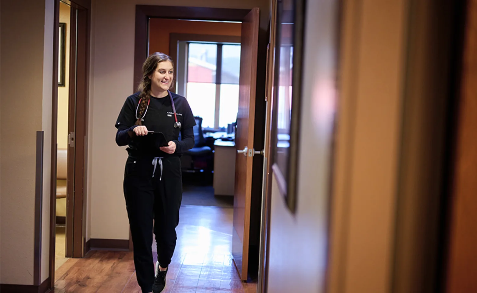 An employee walking through the hall with a smile An employee walking through the hall with a smile