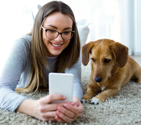 Girl on Phone with Dog Lying on Carpet