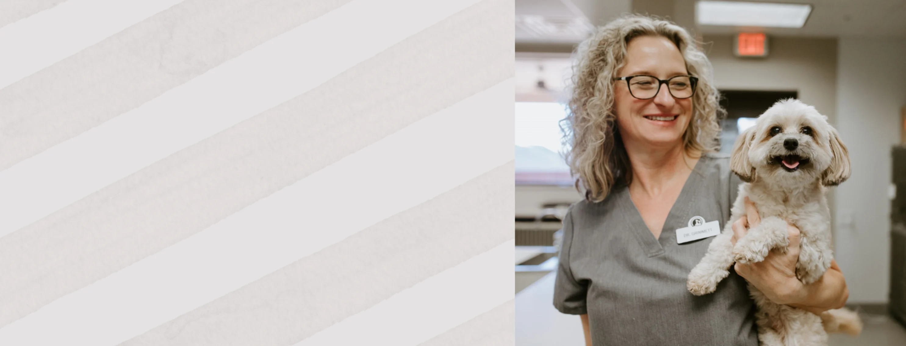 Dr. Grimmett Holding a White Smiling Dog Dr. Grimmett Holding a White Smiling Dog