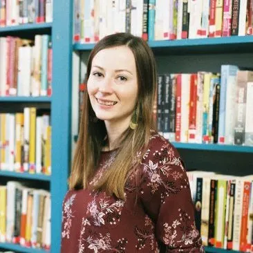 krista watson standing in front of some books