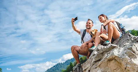 dog and people taking photo on rock ledge