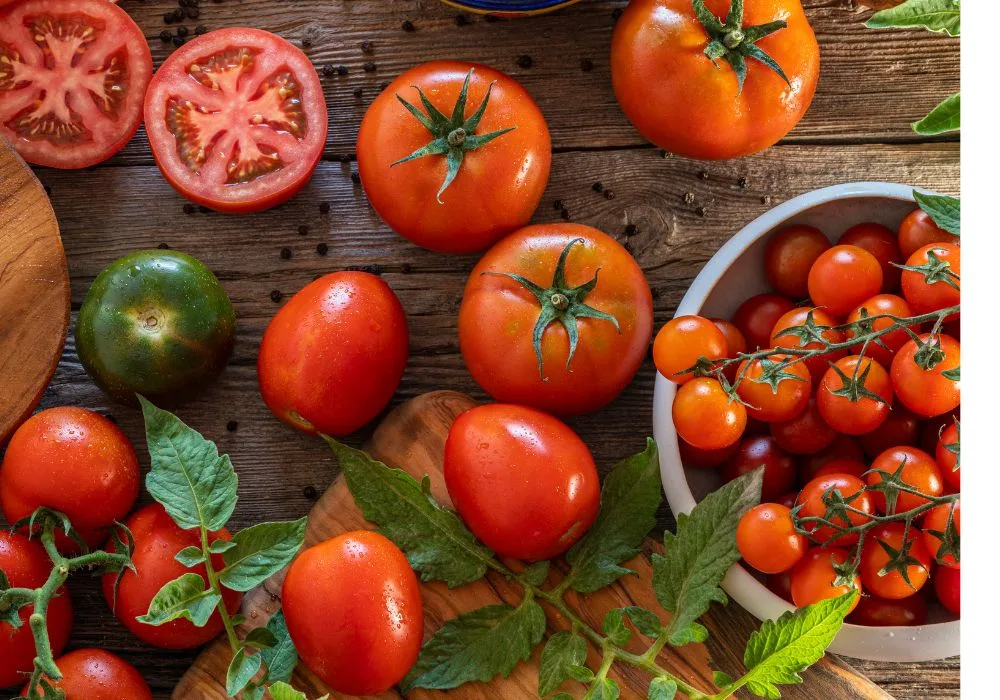 A Vibrant Display of Ripe Red Beefsteak, Green Heirloom, and Cherry Tomatoes on Rustic Wood