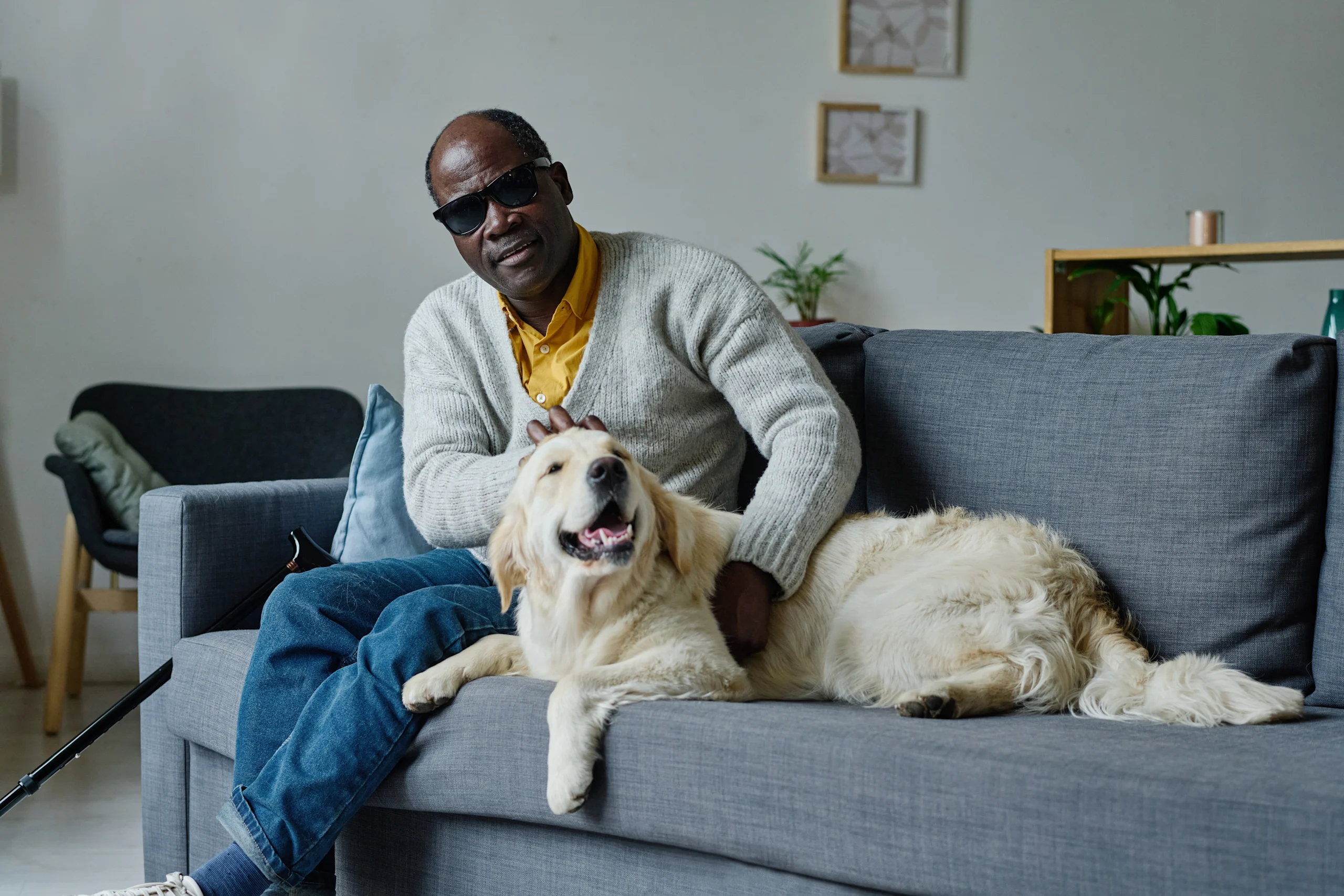Visually Impaired Man Relaxing With His Guide Dog at Home