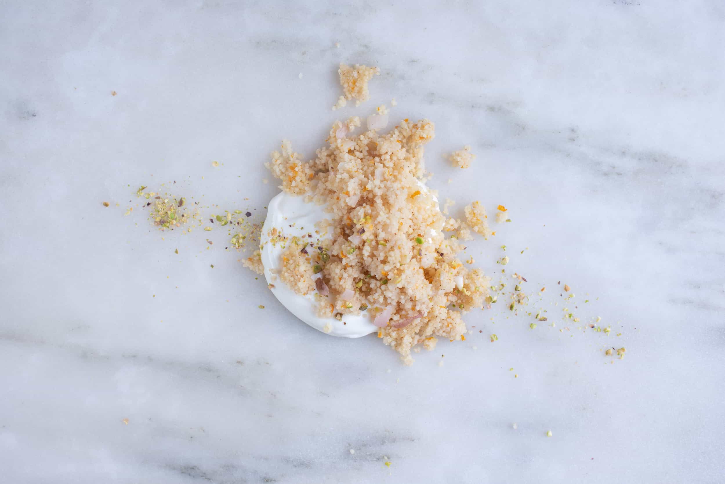 pile of couscous atop yogurt, sitting on a countertop