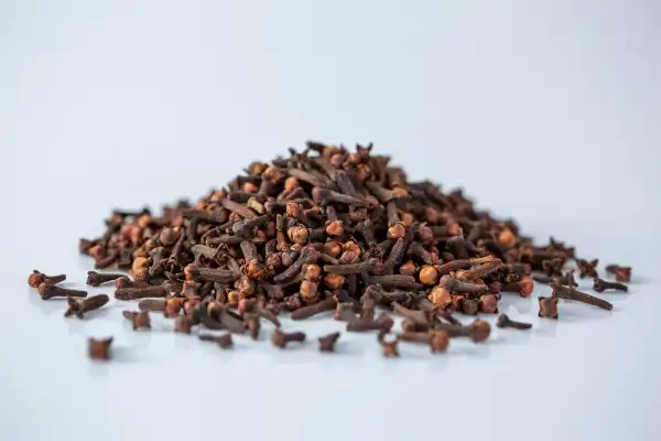 a pile of whole cloves on a white background