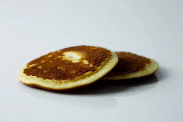 two pancakes, one on top of the other, on a white background