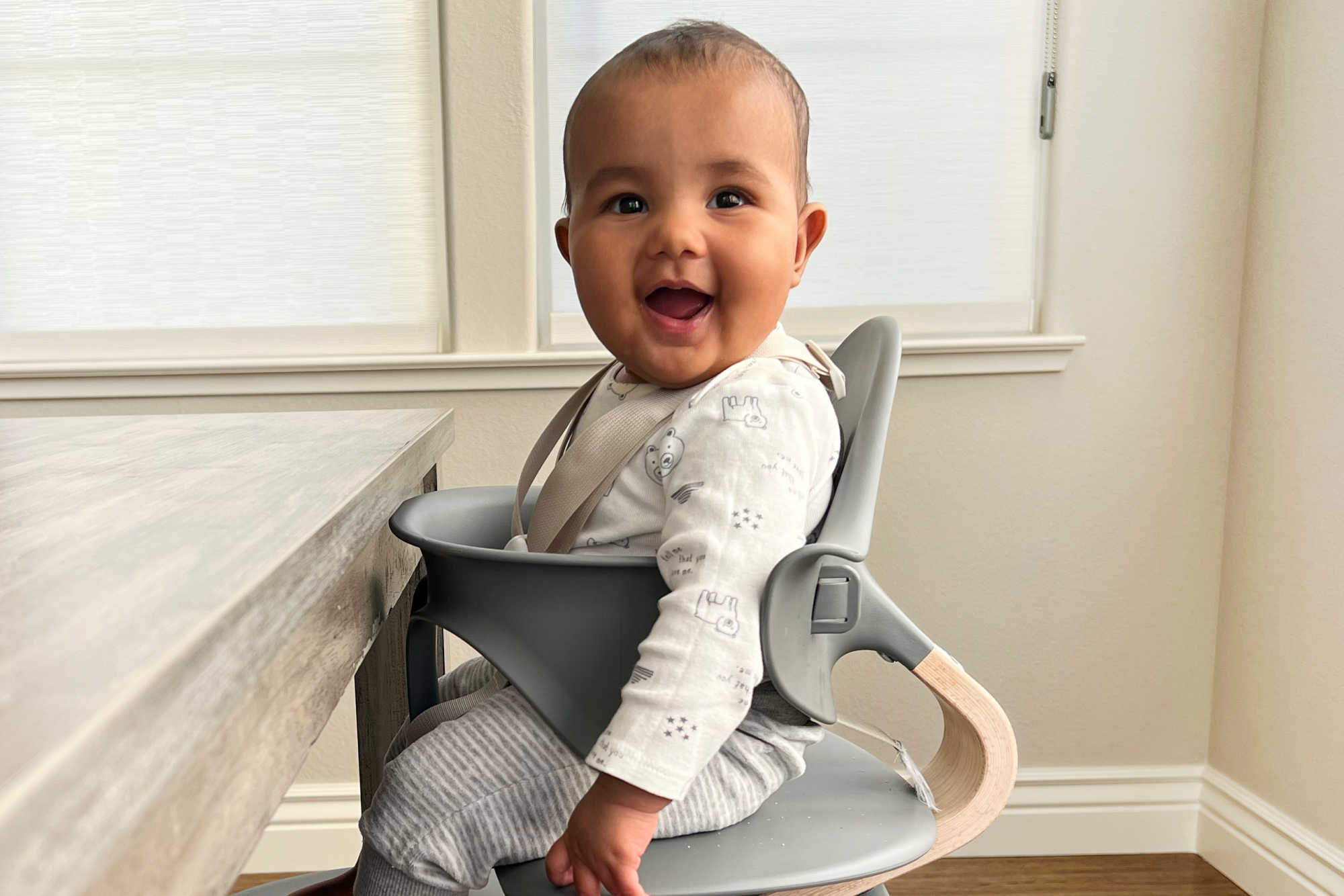 a baby sitting upright in a high chair 
