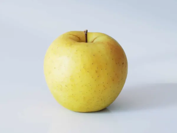 a golden delicious apple on a table before being prepared for babies starting solid food