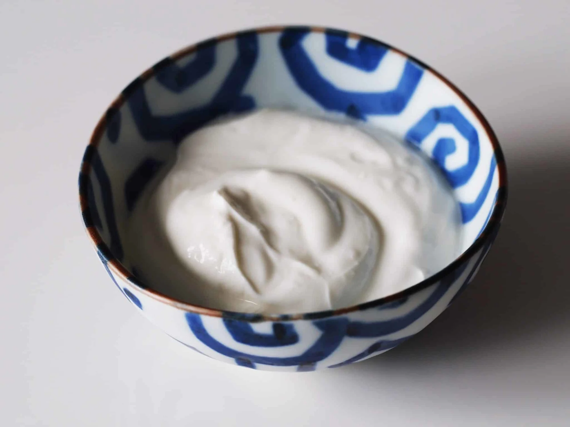 A bowl of yogurt being prepared for a baby starting solid foods