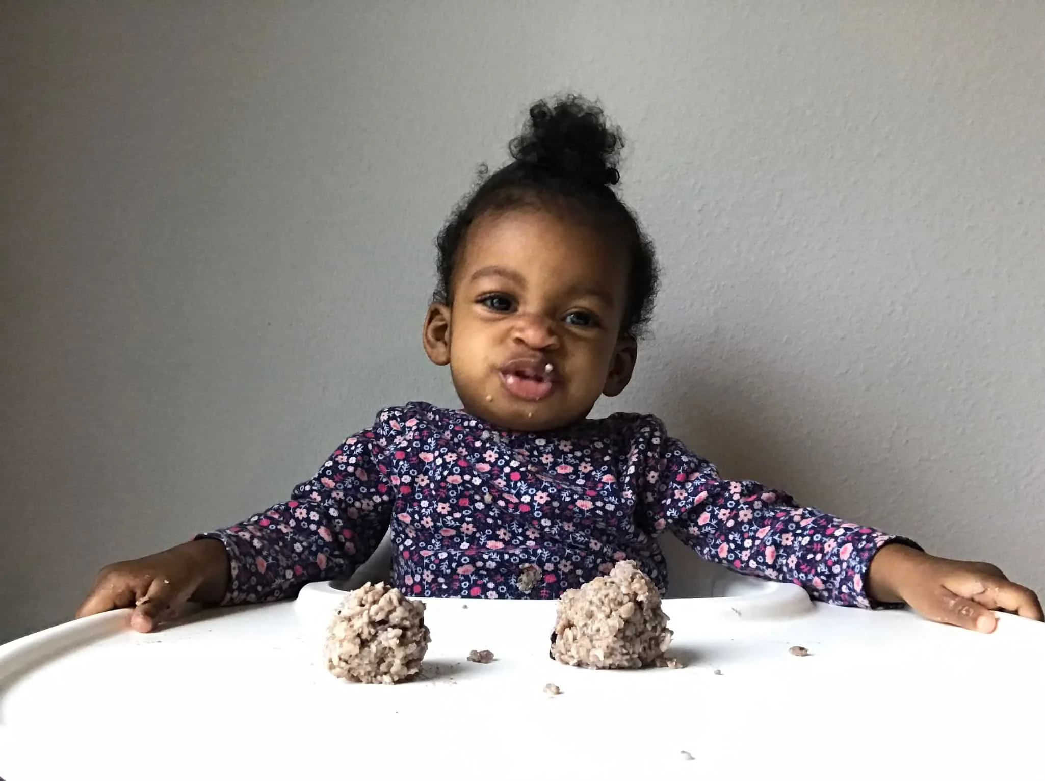 Amaris, starting solids with oatmeal, in her high chair