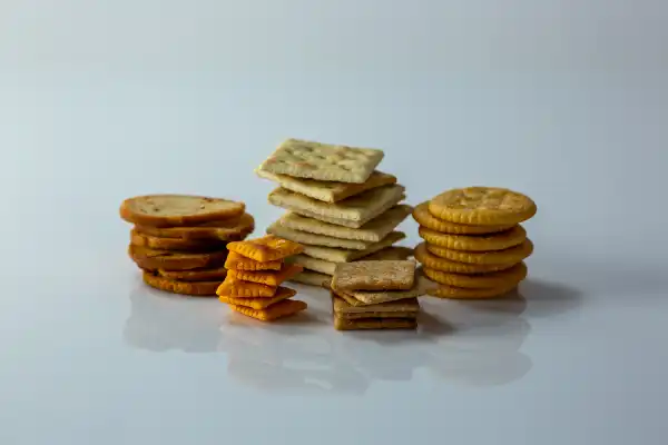 five short piles of different kinds of crackers on a white background