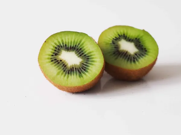 A kiwi cut in half on a table before being prepared for babies starting solid food
