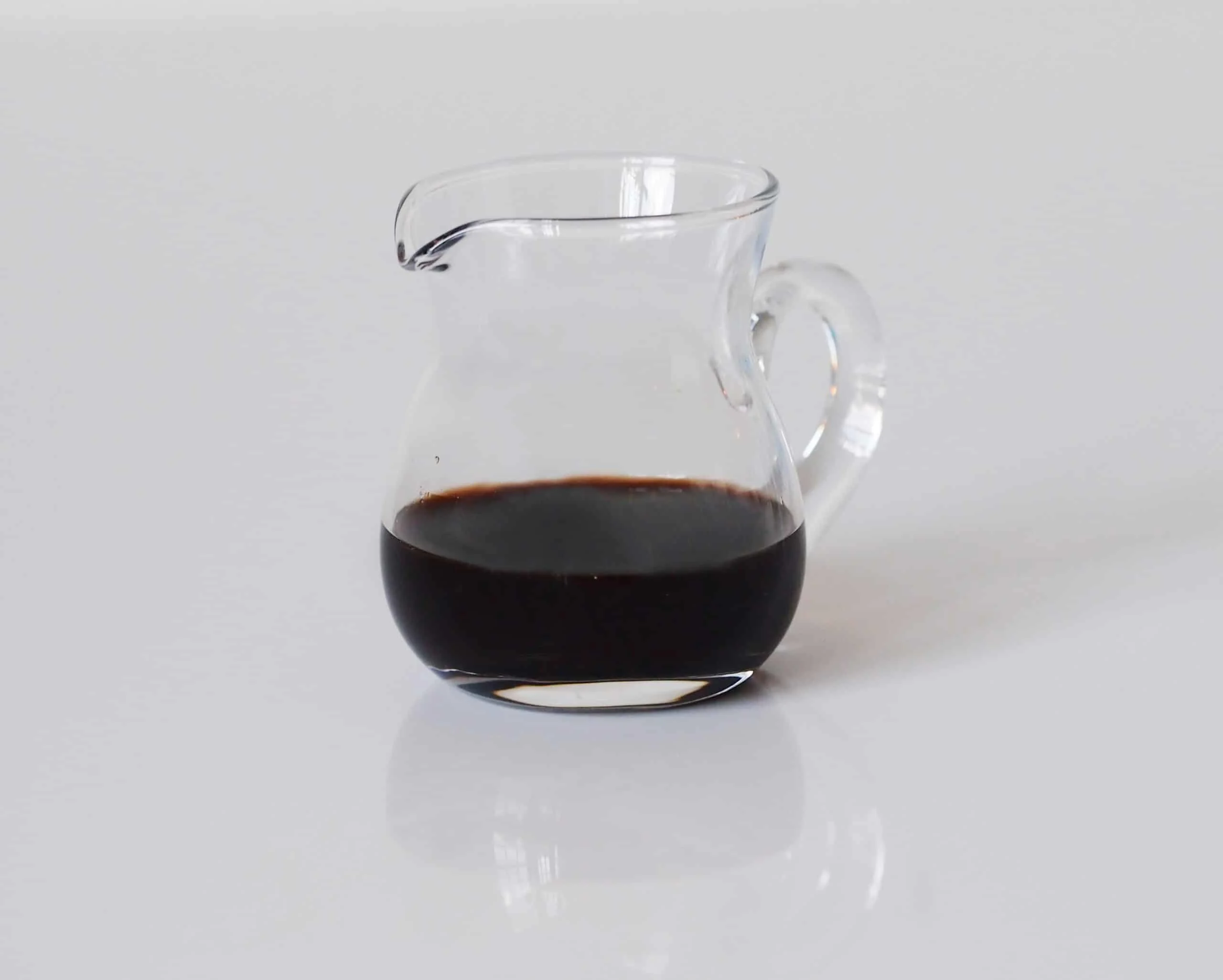 a small glass pitcher a third full of balsamic vinegar