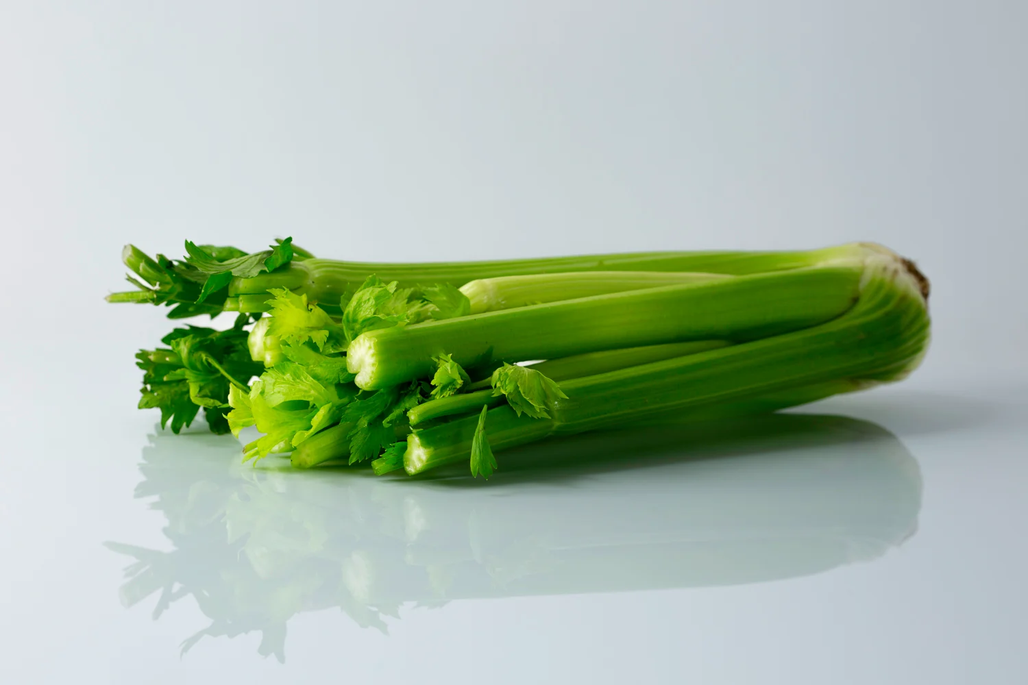 a bunch of raw celery stalks on a table before being prepared for babies starting solid food