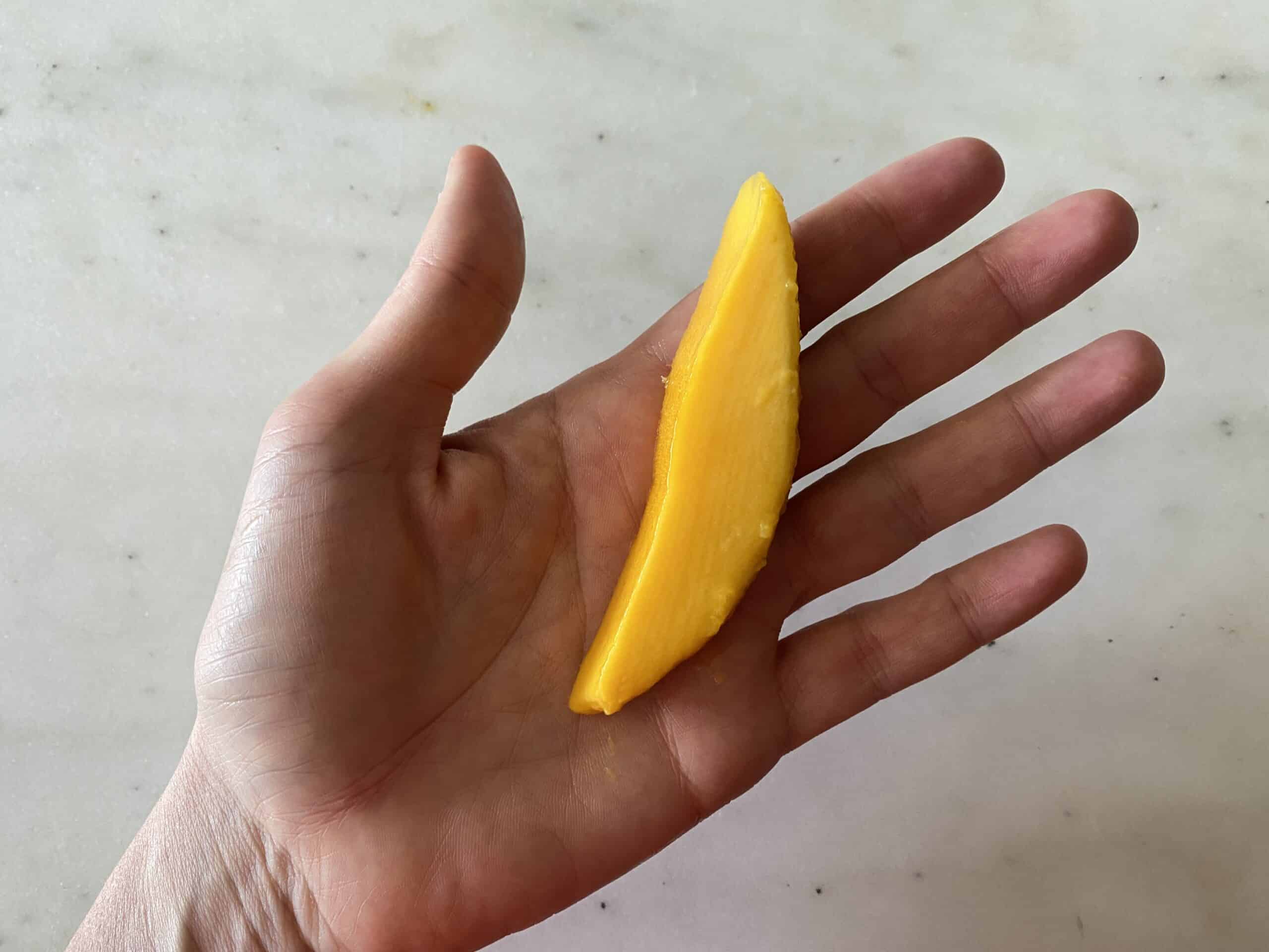 hand holding a mango spear