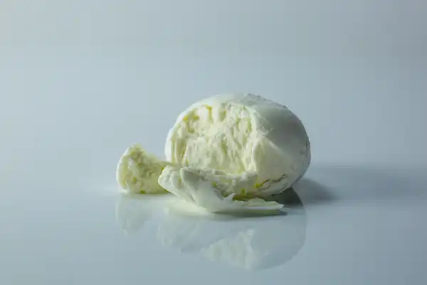 a ball of burrata broken open to see the cream inside