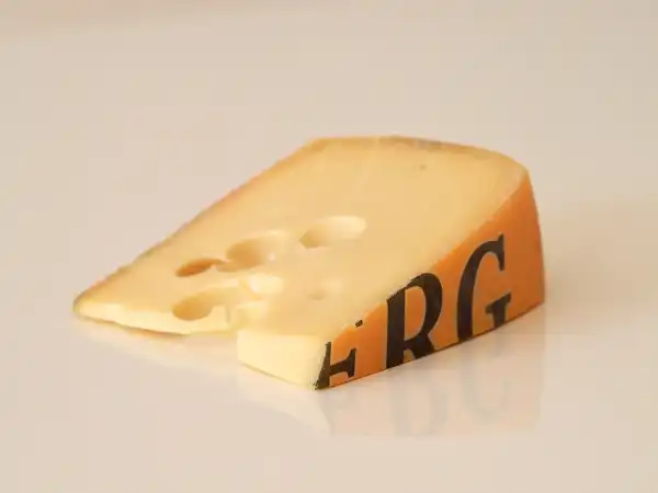 a wedge of Jarlsberg cheese on a white background