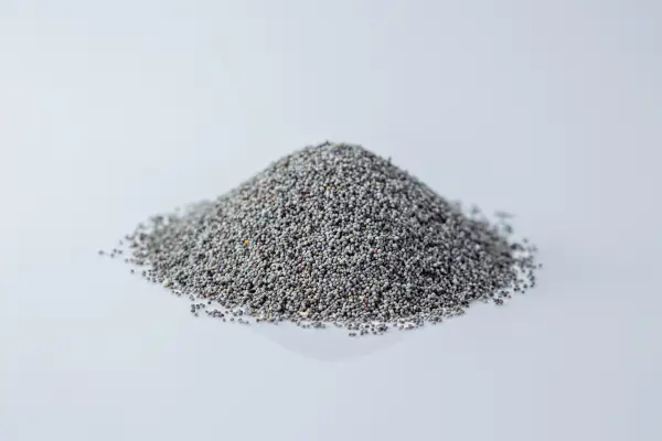a pile of dark poppy seeds on a white background