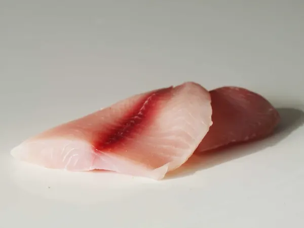 a raw tilapia fillet on a table before being prepared for babies starting solids