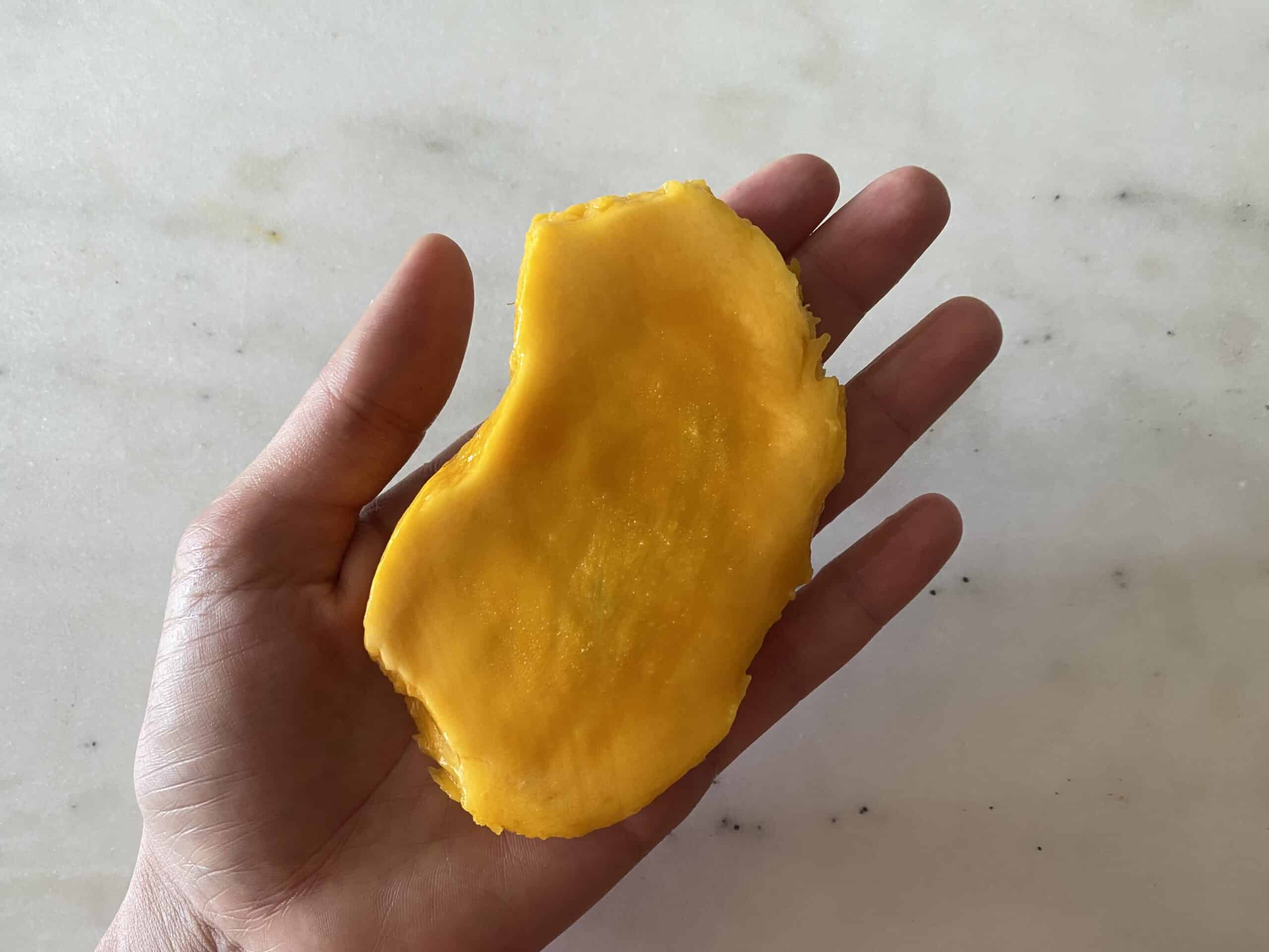 hand holding a mango pit