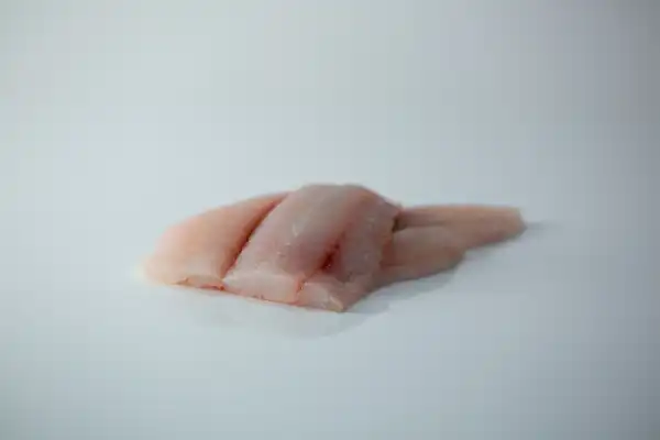 two skinless fillets of flounder on top of each other on a white background