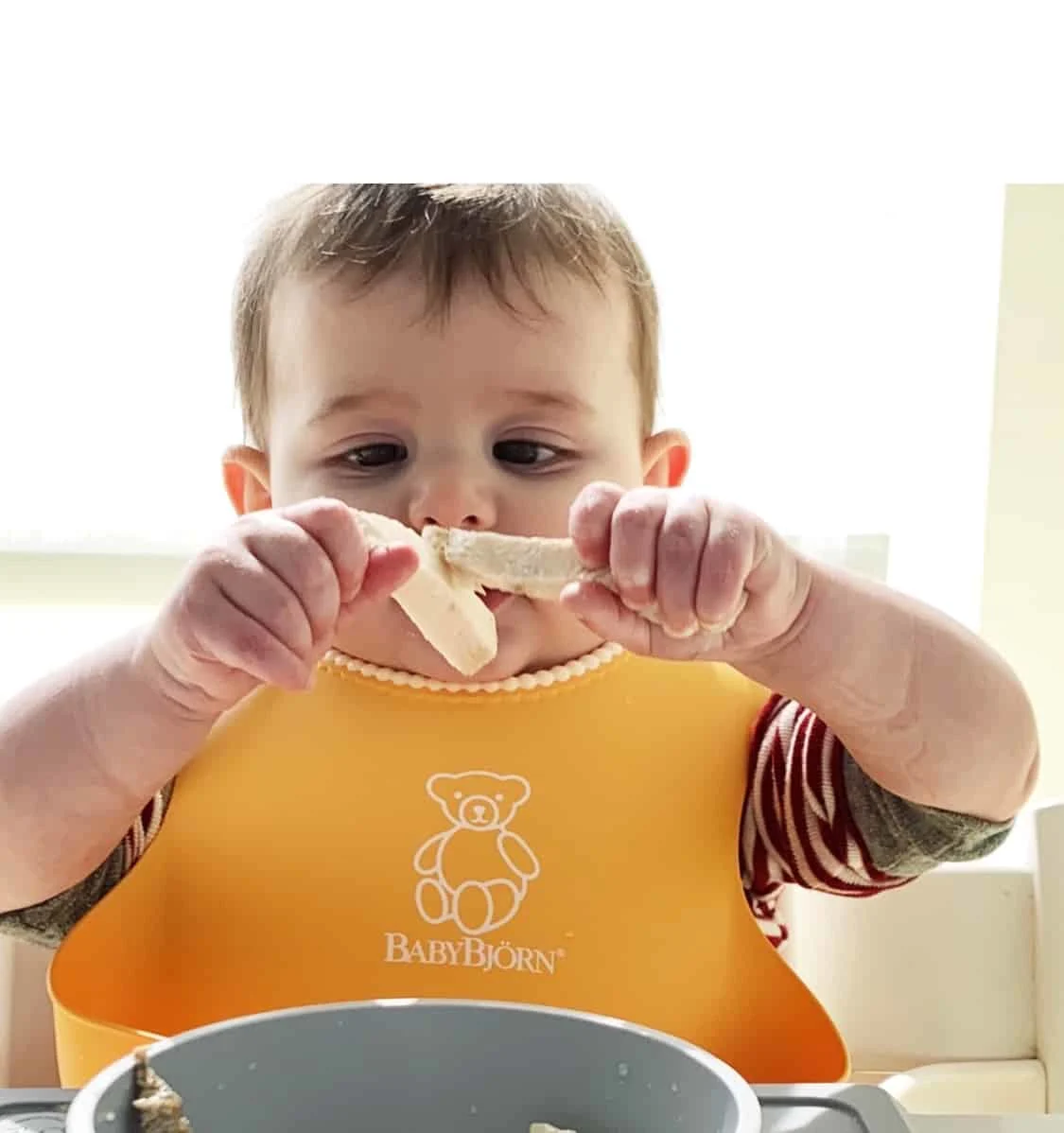 Example of baby eating food with fingers.
