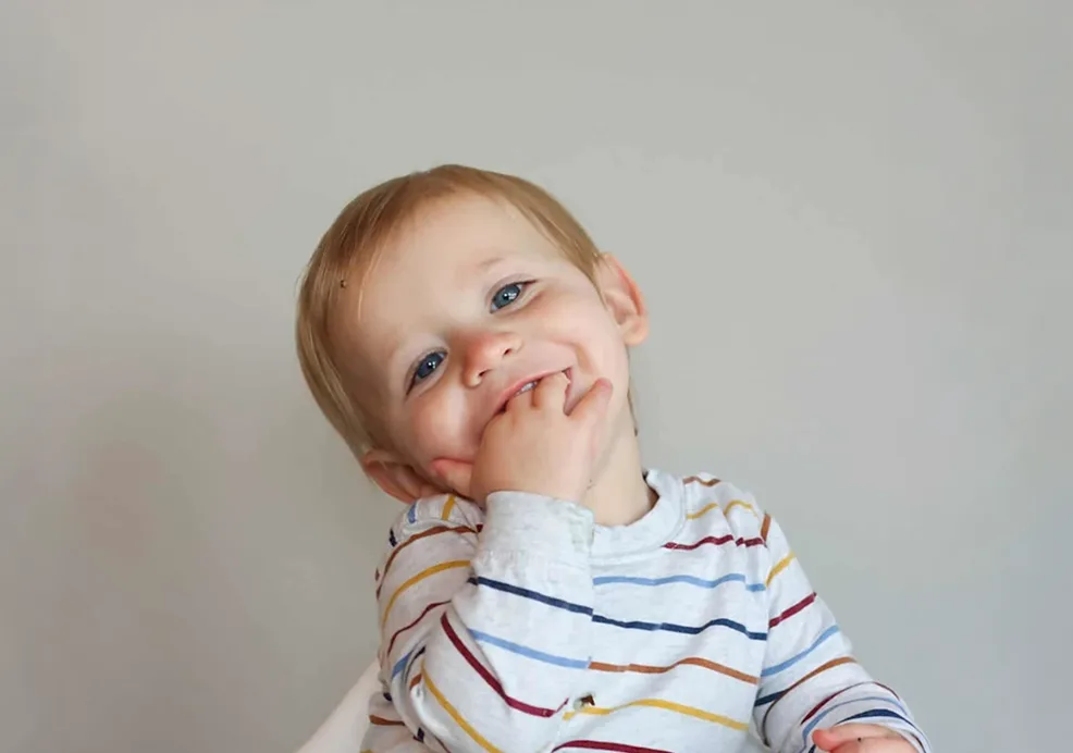 a toddler eating wild rice from a high chair tray