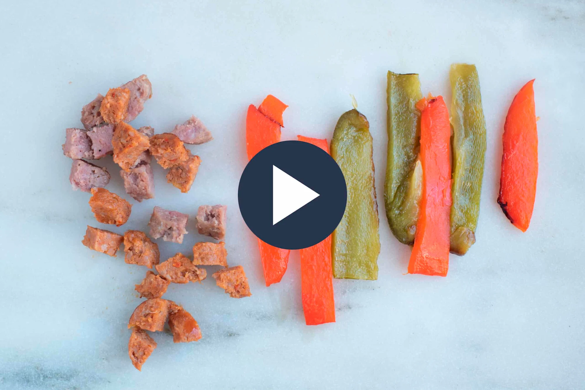 comida cortada en pedazos y lanzas cocinadas de pimentón rojo y verde sobre un fondo blanco