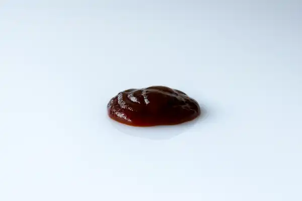 a photograph of a blob of barbecue sauce on a white background