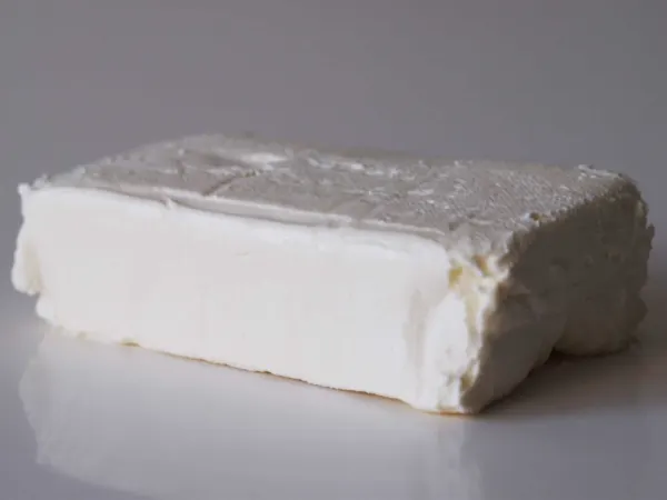 a block of cream cheese on a table before it is being prepared for a baby starting solid food