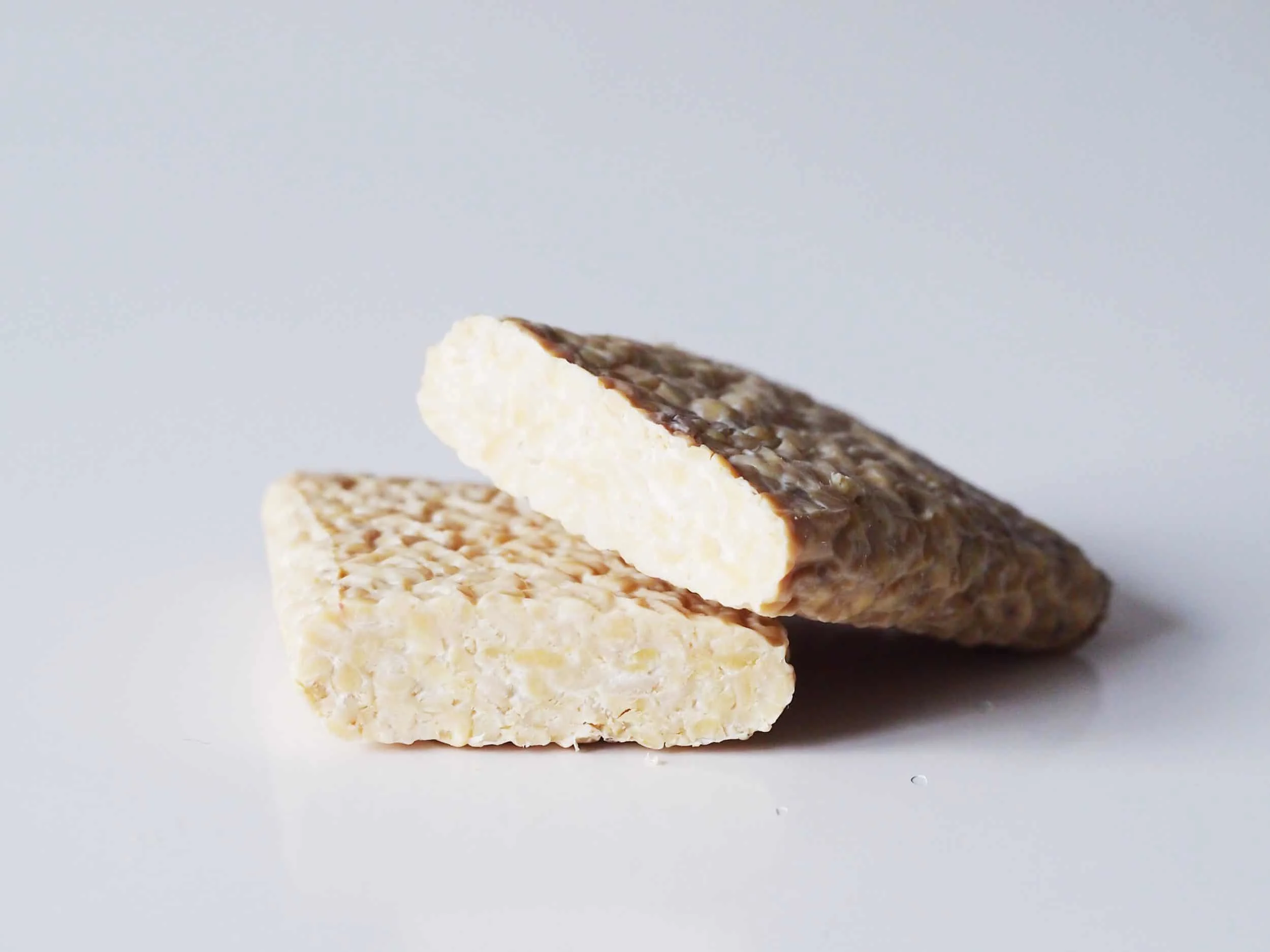 a block of raw tempeh cut in half on a table before being prepared for babies starting solid food