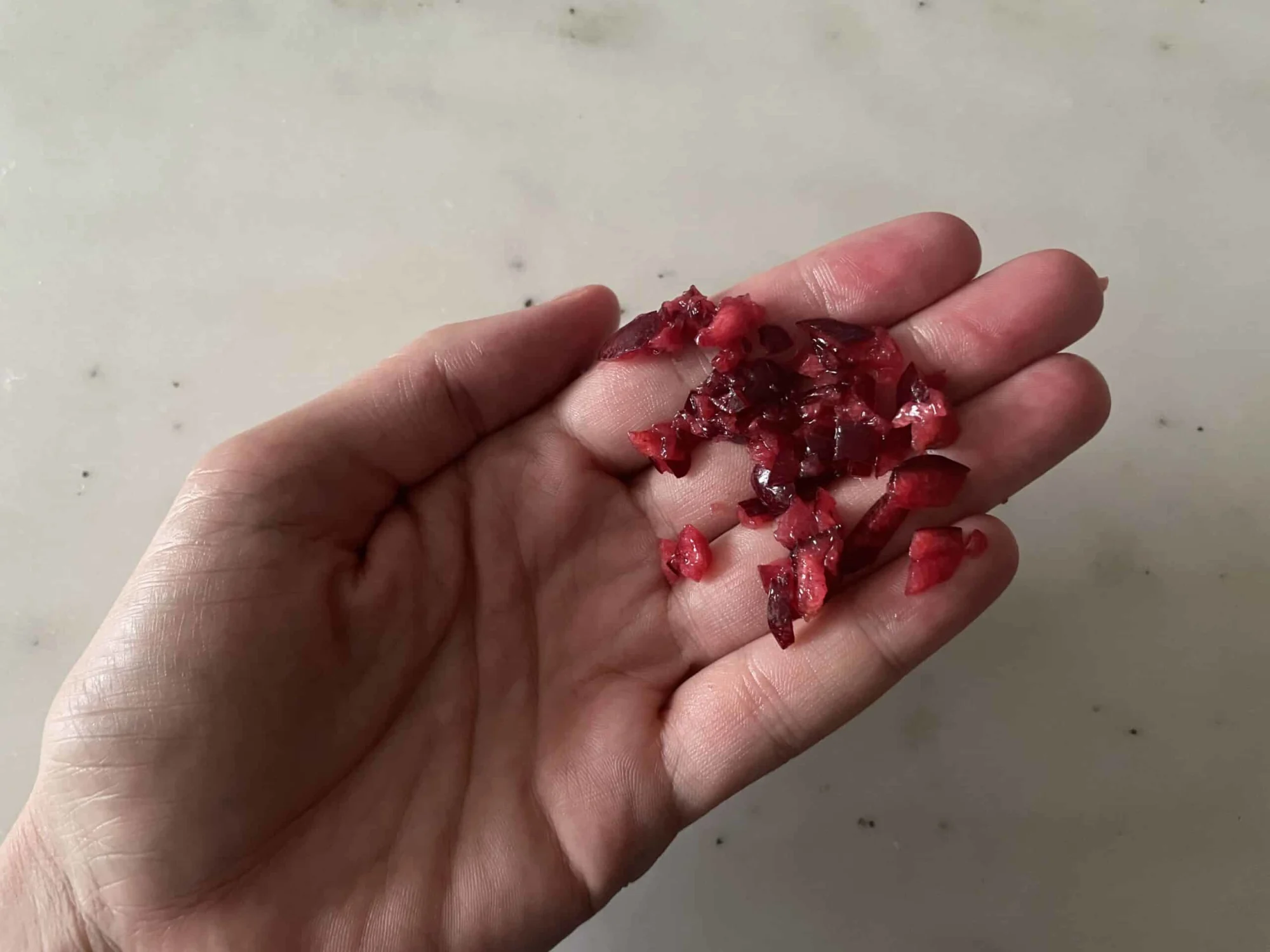 a hand holding minced cherry for young babies