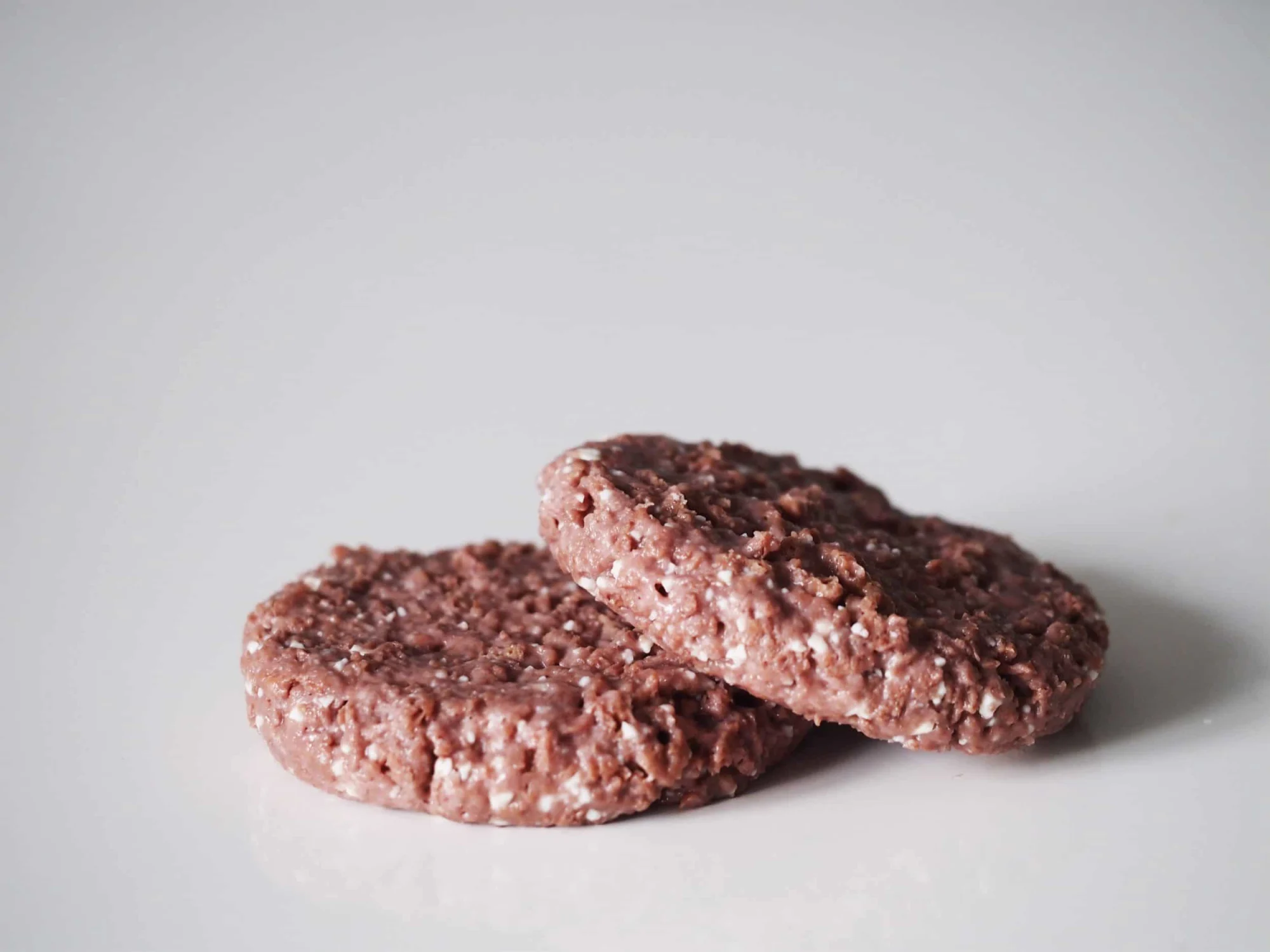 two beyond meat burger patties on a white table before being prepared for babies starting solid food