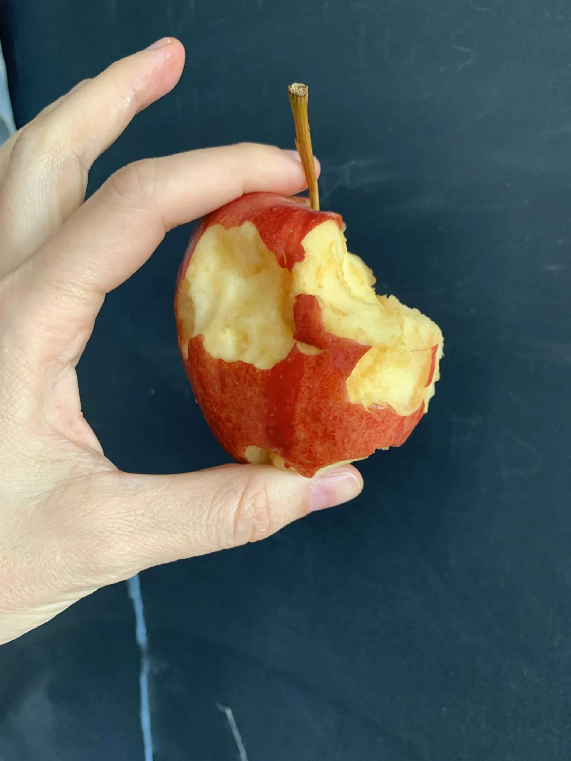 A whole apple with bites taken out of it from a picky eater