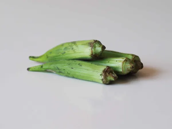 3 okra pods on a table before being prepared for babies starting solid food